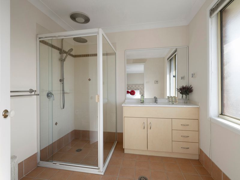 The stylish ensuite features a walk-in shower and a spacious vanity.