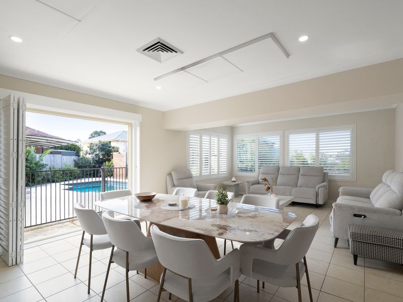 Enjoy poolside views from the open-plan living and dining area with plantation shutters throughout.