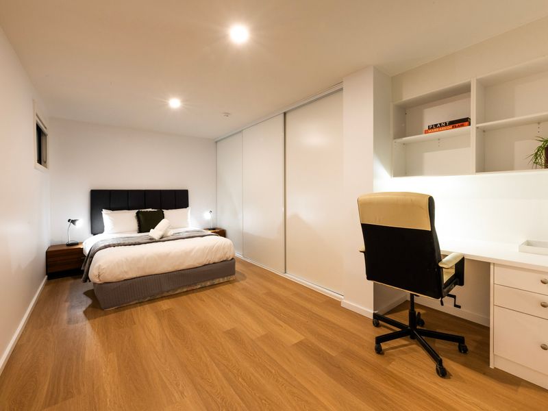 Comfortable bedroom setup featuring a dedicated desk and chair, along with a relaxed sitting area for reading, working, or unwinding during your stay.