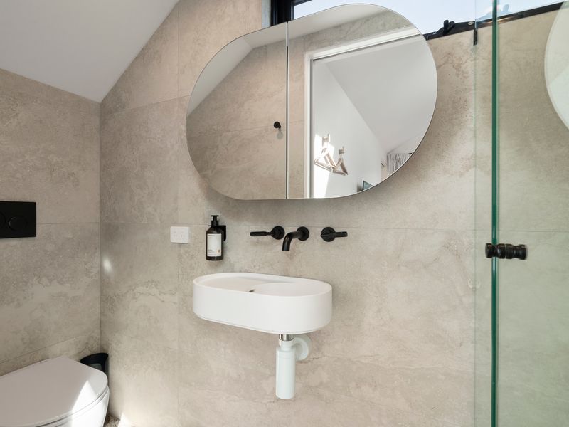 Well-appointed loft bathroom with shower and toilet and fresh, stylish detailing