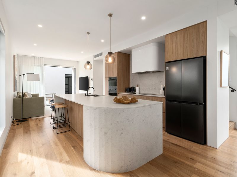 Open-plan living, dining and kitchen area with natural light and comfortable seating