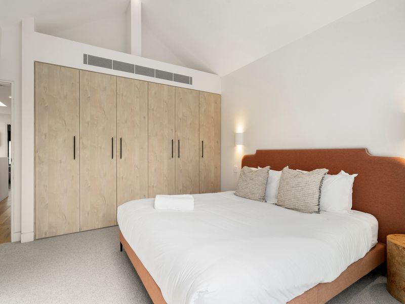  Light-filled bedroom with soft furnishings and wardrobe space