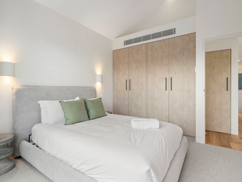 Spacious  bedroom with comfortable queen bed and built-in storage