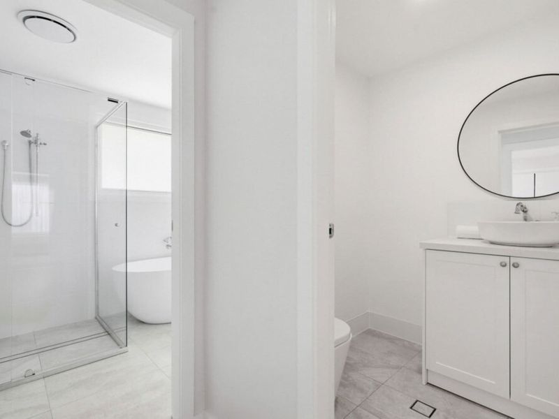 Bright bathroom with spacious shower and vanity.