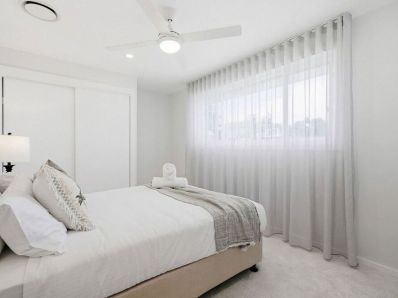 Peaceful bedroom with soft linens and natural light.