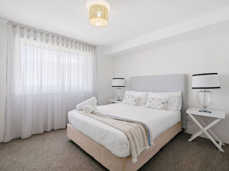 Peaceful queen bedroom with soft natural light.