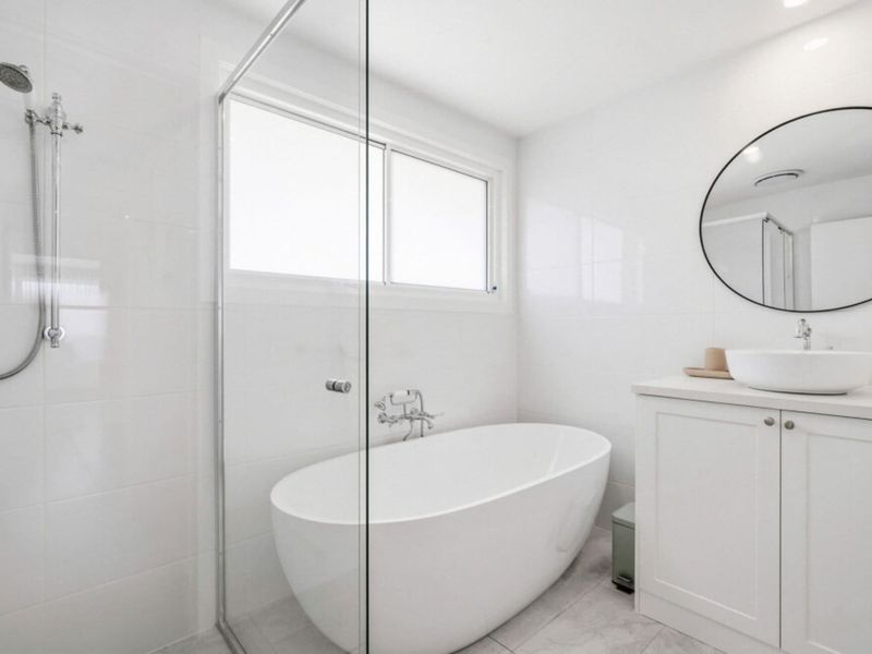 Modern bathroom with freestanding bathtub and walk-in shower.