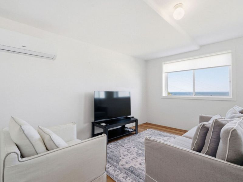 Comfortable lounge with Smart TV and coastal outlook.