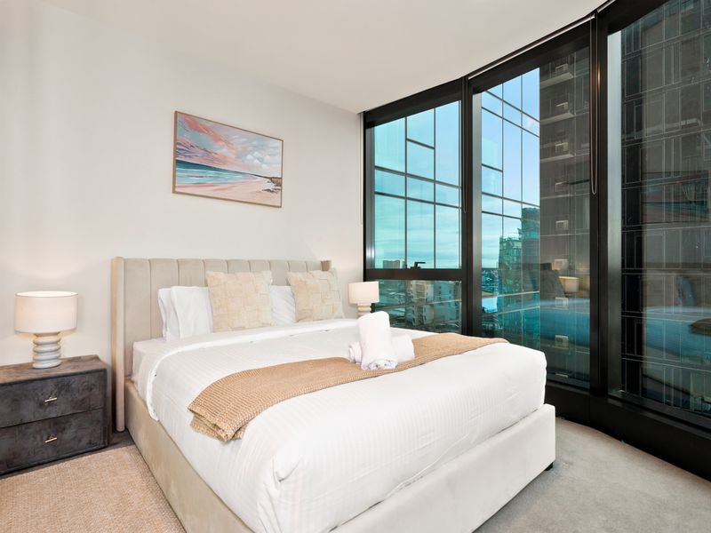 Serene bedroom sanctuary framed by stunning city outlooks.