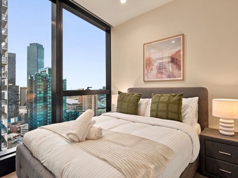 Light-filled bedroom with sweeping skyline views and cozy touches.