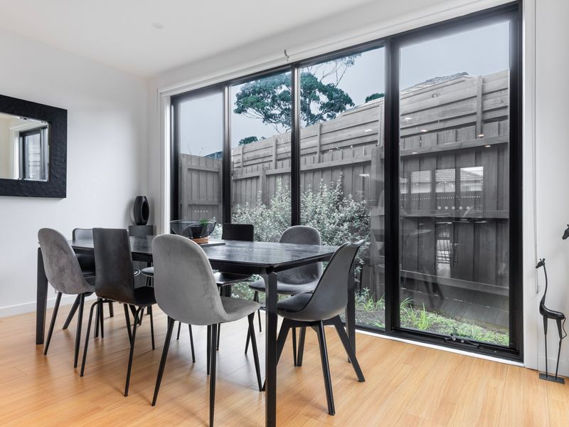 Floor-to-ceiling windows bring the outdoors in, creating a bright and inviting dining space.