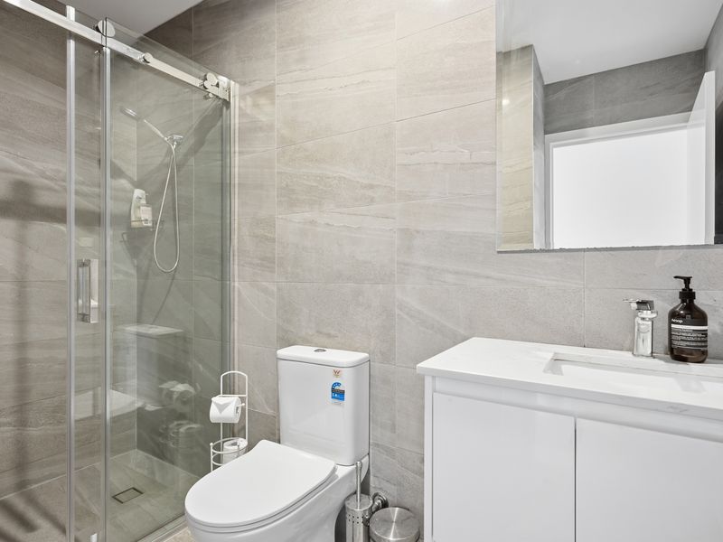 The stylish bathroom offers a spacious walk-in shower and modern vanity for everyday comfort.