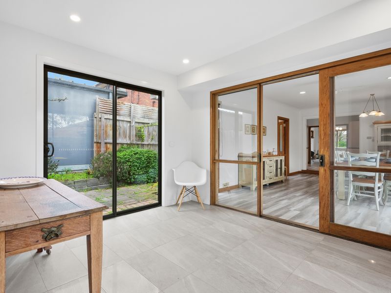 Large glass doors create a seamless connection between the indoor living space and the private garden.
