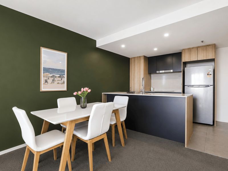 Dining space set for four beside the fully equipped kitchen.