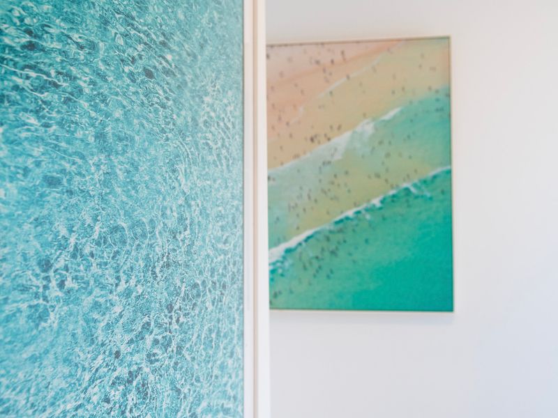 Coastal-inspired artwork complements the home's relaxed beachside atmosphere.
