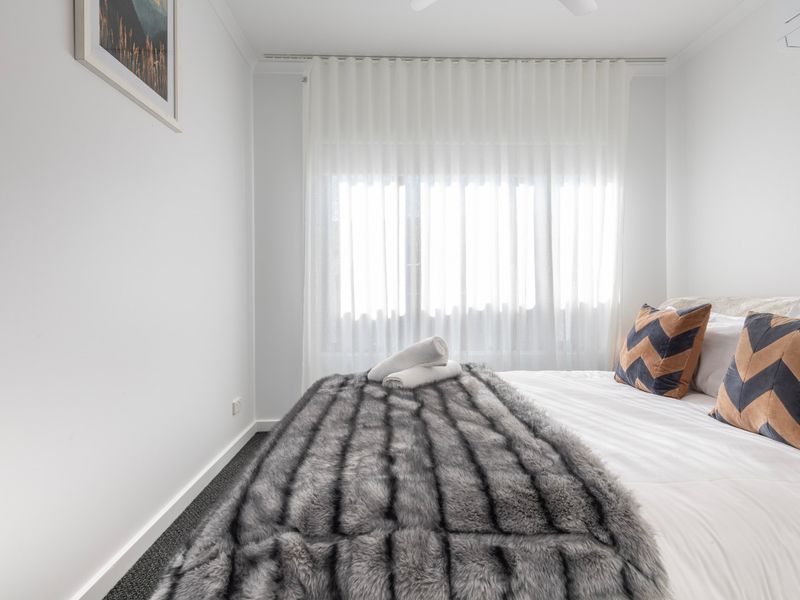 The second bedroom offers a peaceful retreat with soft linens and plenty of natural light.