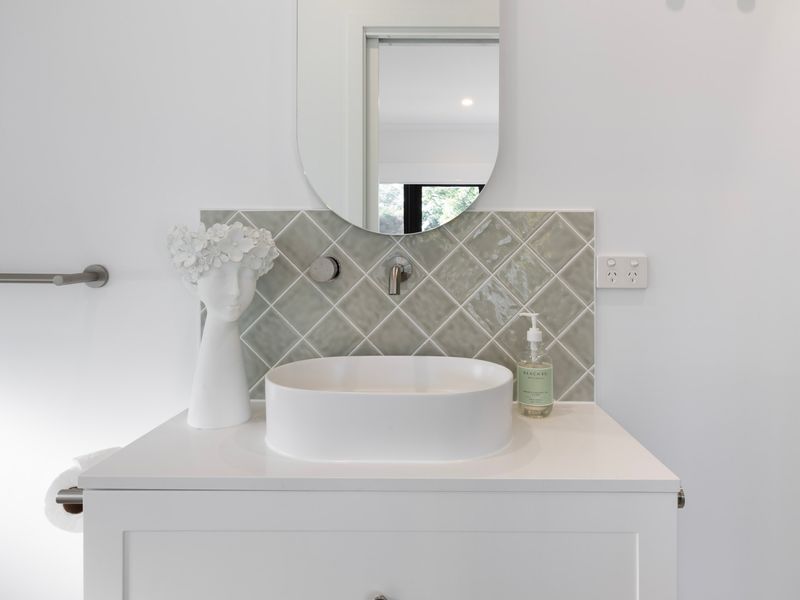 Freshen up in the stylish bathroom featuring a contemporary vanity and quality finishes.