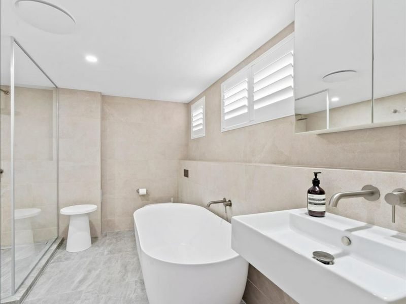 Unwind in the luxurious bathroom complete with a freestanding bathtub, walk-in shower, and elegant finishes.