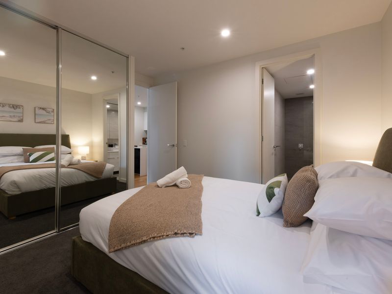 Mirrored wardrobes provide convenient storage while enhancing the room's sense of space.