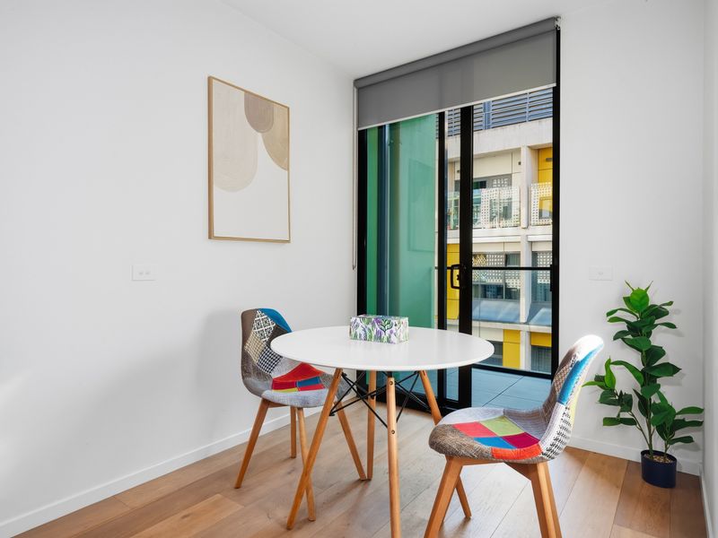 Floor-to-ceiling balcony doors invite natural light into the dining area throughout the day.