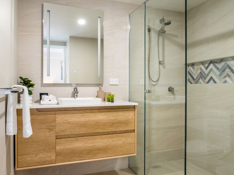 Modern bathroom with vanity and walk-in glass shower.