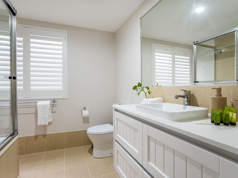 Bright bathroom with quality finishes and ample bench space.