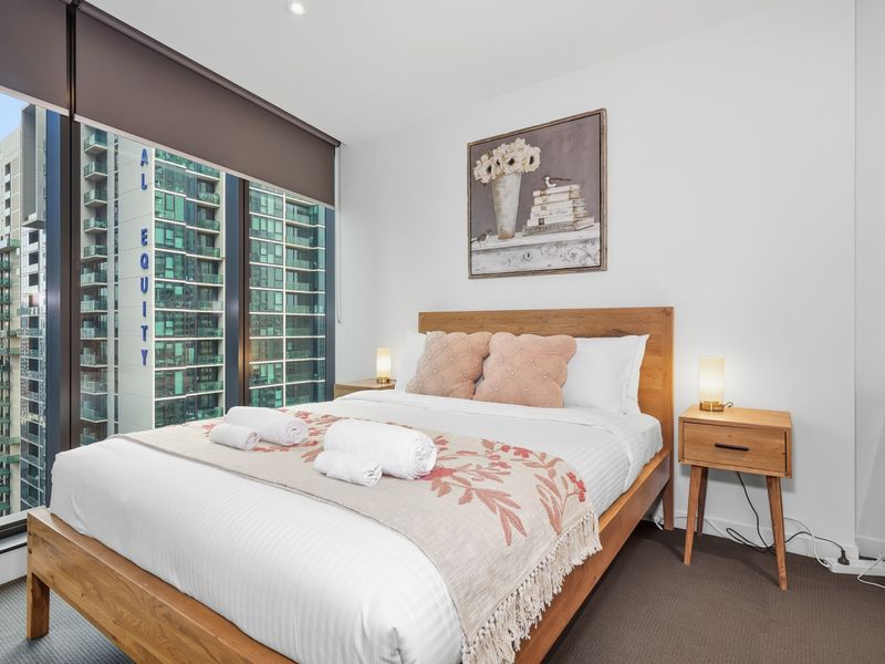 Enjoy restful nights in a bright bedroom overlooking the vibrant city skyline.