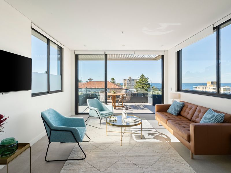 The spacious living area seamlessly connects to the balcony and ocean beyond.