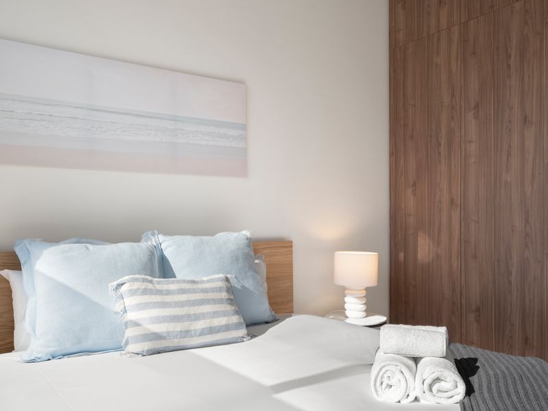 Warm timber accents create a sophisticated and relaxing bedroom atmosphere.
