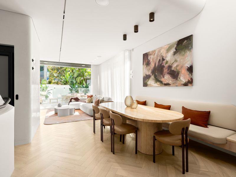 Dining space positioned beside full-height windows for natural light.