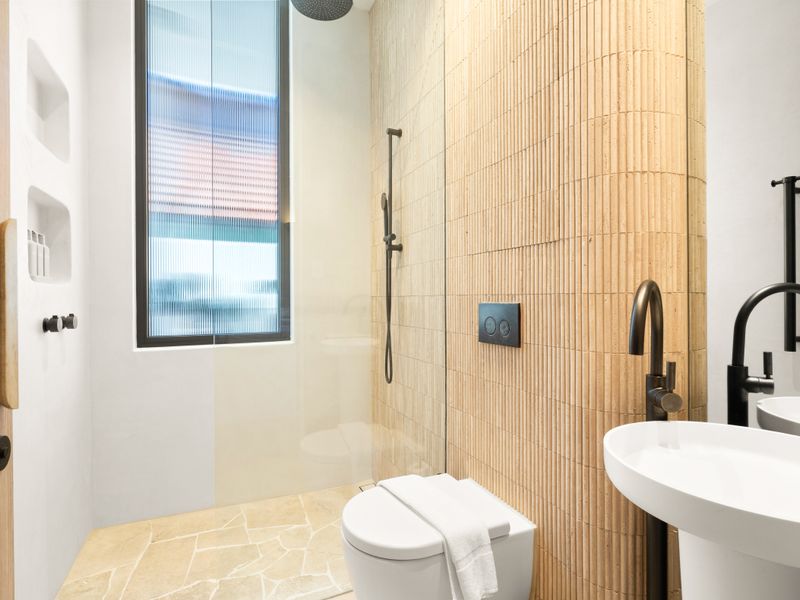 Designer bathroom featuring a walk-in shower and modern black fixtures.