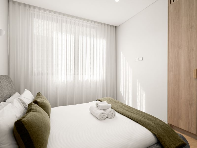 Bright guest bedroom with soft natural light and built-in wardrobe.