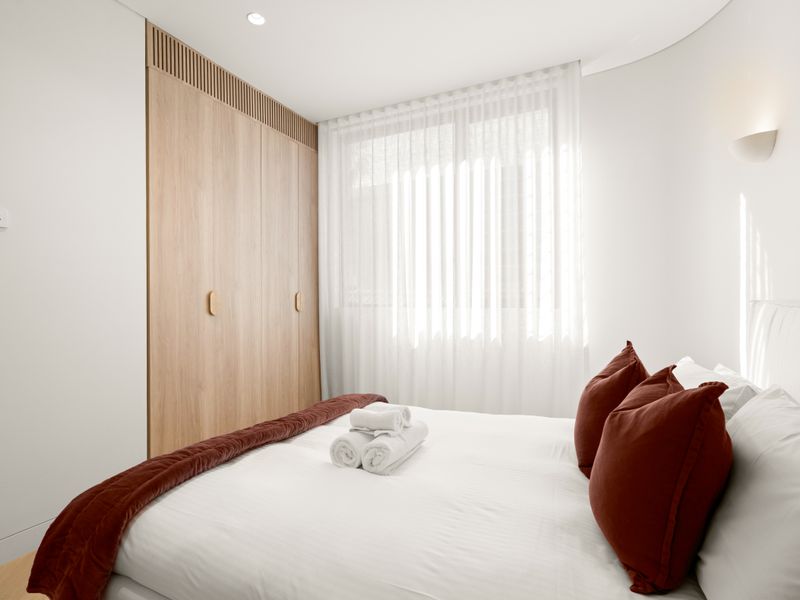 Inviting bedroom with floor-to-ceiling wardrobes and natural light.