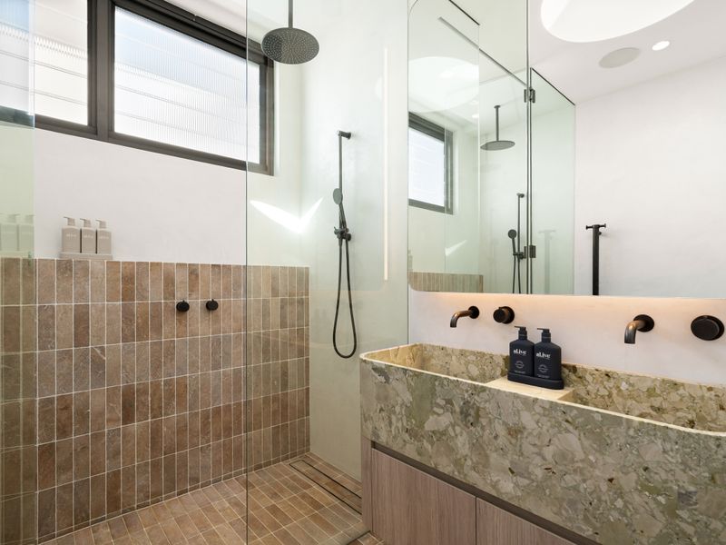 Designer bathroom complete with dual showers and statement stone vanity.