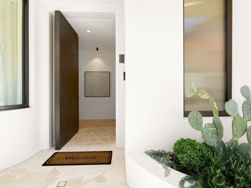Welcoming private entrance framed by modern landscaping.