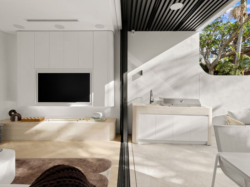 Covered outdoor living space with integrated BBQ and TV.