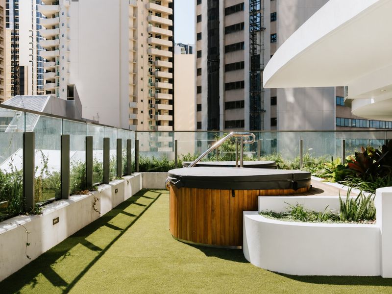 Rooftop spa surrounded by landscaped outdoor spaces.