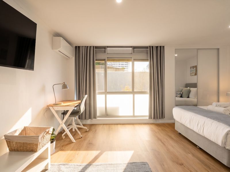 Peaceful bedroom with Smart TV and workstation.