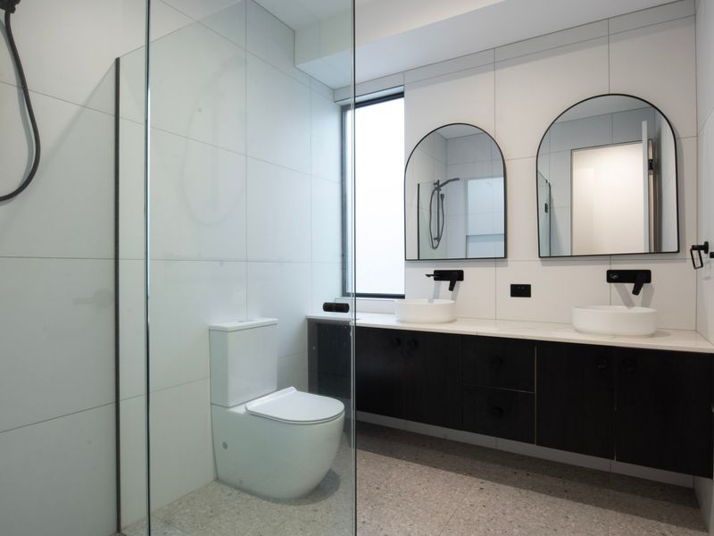 Modern ensuite bathroom with double vanity and walk-in shower.