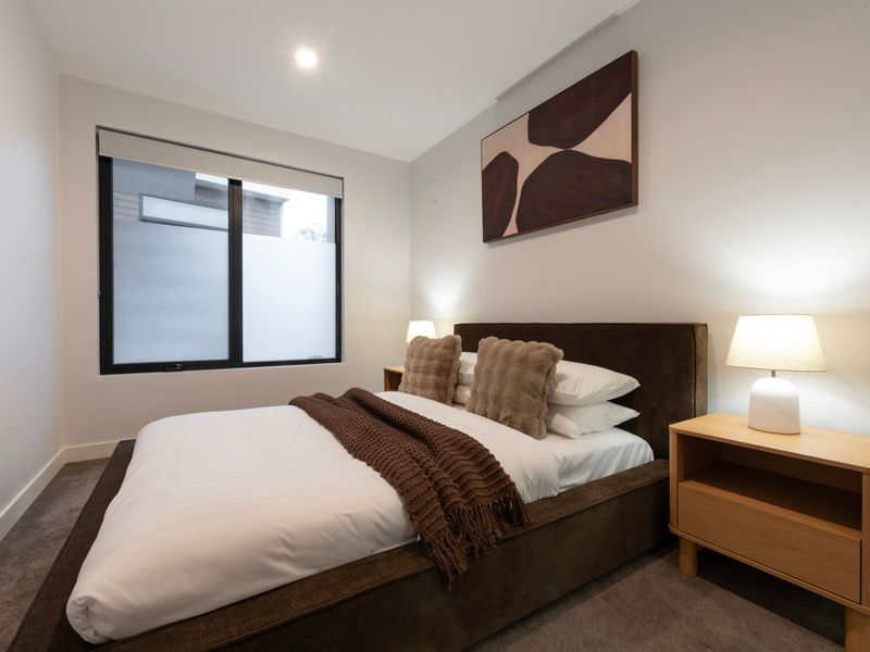 Peaceful queen bedroom with quality linen and bedside lighting.