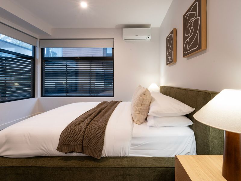 Spacious queen bedroom with split-system air conditioning.