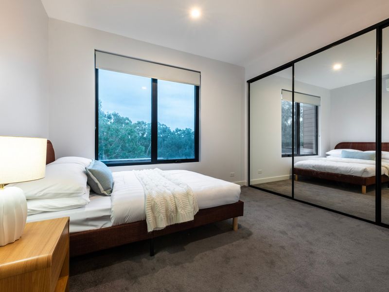 Spacious bedroom with mirrored built-in wardrobes.