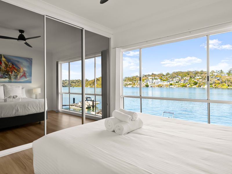 Serene bedroom with water views beyond