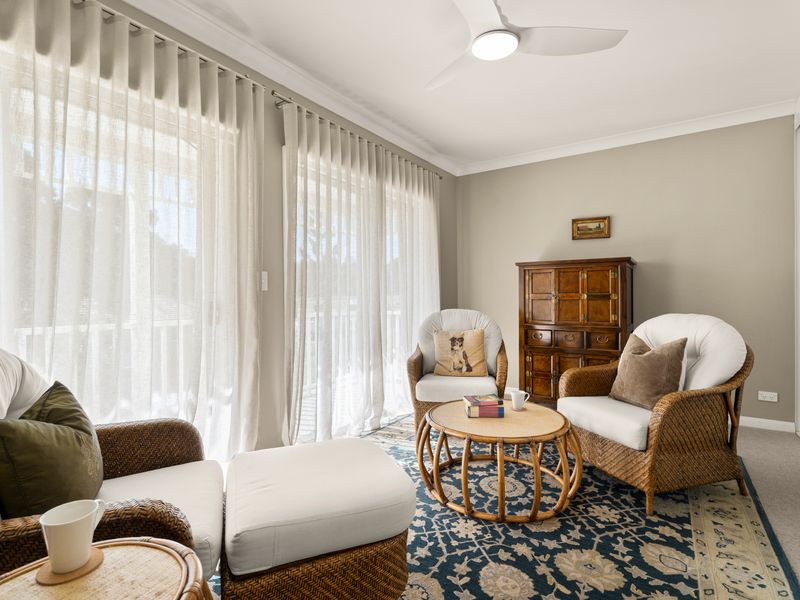 Peaceful bedroom with lovely park views through large windows.