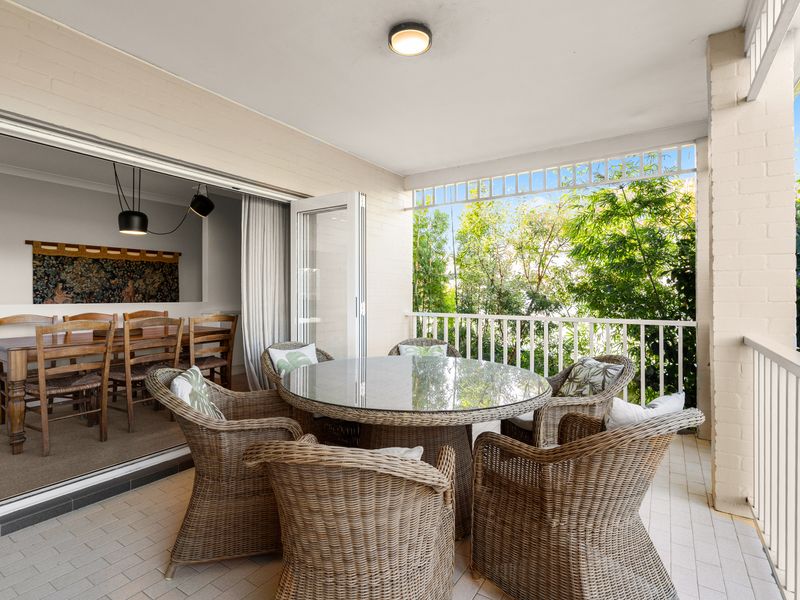 Covered balcony with outdoor lounge and dining space.