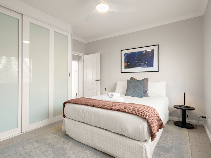 Third bedroom with built-in wardrobes and comfortable bedding.