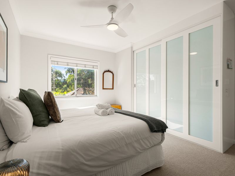 Another view of the bright bedroom with built-in storage.