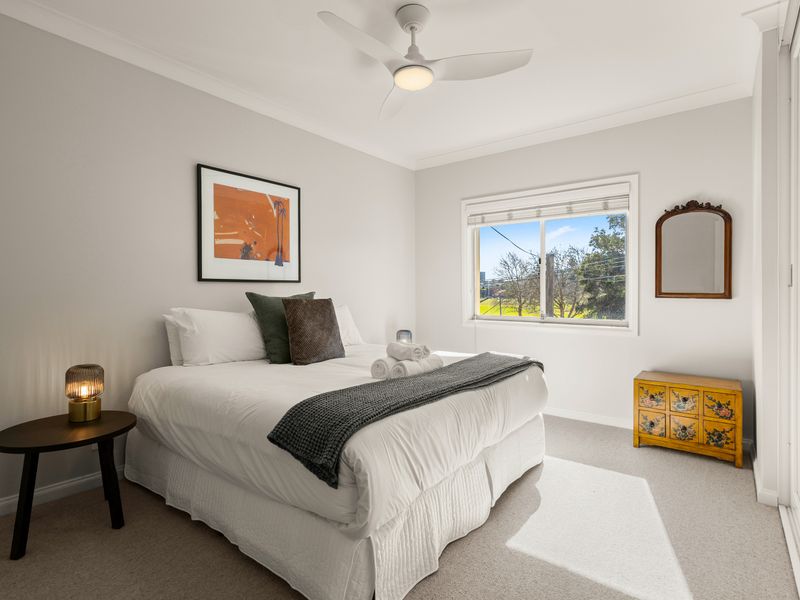 Second bedroom with a queen bed and leafy outlook.
