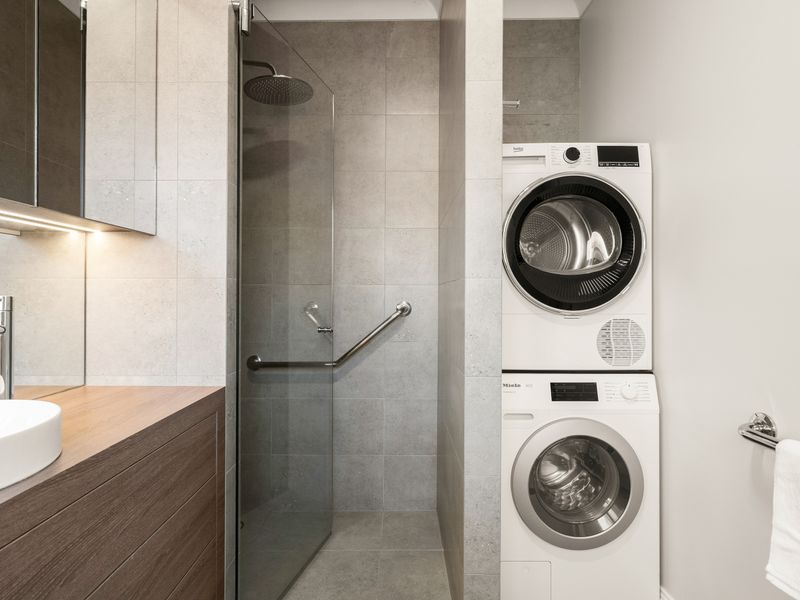Convenient laundry nook integrated into the modern bathroom.