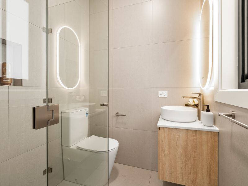 Contemporary bathroom with a walk-in shower and illuminated vanity.
